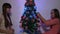 Happy childhood concept. Children decorates the Christmas tree with Christmas balls. Small kids plays by Christmas tree