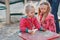 Happy childhood. two blonde sisters play in the Playground in the sand