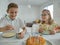 Happy children at birthday party with torte and colorful candles at table at home