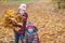 Happy children. girl holding an armful of autumn yellow leaves on the nature walk outdoors