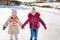 Happy children ice skating on an ice rink outdoors. Sport and a healthy lifestyle. Funny kids, they are sisters and girlfriends