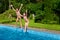 Happy children jump to swimming pool