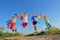 Happy children jumping on field with balloons