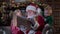 Happy children listen to Christmas story from Santa Claus. Santa is reading book to small children, bright magic light