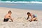 Happy children play together on the beach.