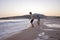 Happy children, playing on the beach on sunset, kids running in the water in the ocean