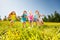 Happy children playing football in yellow meadow