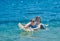 Happy Children Playing with Mattress at Sea