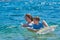 Happy Children Playing with Mattress at Sea