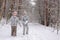 Happy children playing with snow in winter forest, family winter weekend