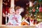 Happy children playing under a beautiful Christmas tree