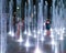 Happy children playing in a water fountain in evening lights