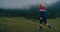 Happy children run on mountain meadow on autumn hike travel in rubber boots