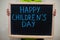 Happy children`s day. Boy hold chalkboard with blue inscription