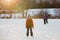 Happy children, skating on a frozen lake in the park