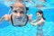 Happy children swim in pool underwater, girls swimming