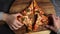 Happy children take slices of ready-made homemade pizza in the kitchen.