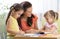 Happy children with teacher drawing in classroom