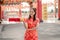 Happy Chinese new year. Asian woman wearing traditional cheongsam qipao dress holding and looking to ancient gold money in Chinese