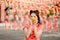 Happy Chinese new year. A young lady wearing traditional cheongsam qipao dress holding ancient gold money in Chinese Buddhist