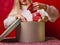 Happy Christmas. Preparing Christmas presents. Woman puts red socks with patterns in a large striped gift box