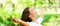 Happy clean air Asian woman breathing in fresh outdoor nature forest panoramic banner for allergy free pollen allergies