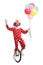 Happy clown riding a unicycle, holding a bunch of balloons and waving at the camera