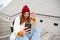 Happy college girl talks with friends on video chat smartphone app, sits on stairs outdoors uses her mobile phone