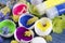 Happy colorful Easter decoration with egg shells filled with paints and spring flowers