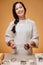 Happy confectioner woman on a yellow background prepares ginger dough.