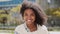 Happy confident pretty young African American woman on street, portrait.