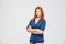 Happy confident redhead young woman standing with arms crossed