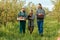 Happy contented family horticultural farmer walks their own property crates of crops in their hands.