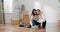 Happy contented young couple moves into their first apartment together, couple sits on a wooden floor close together, an