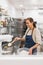 Happy cook putting flour in blender in bakery