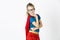Happy and cool blond supergirl with glasses and red robe und blue shirt is posing in the studio