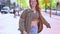 Happy cool teen redhead hipster girl model walking on big city street.