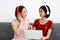 Happy Couple  asia woman wear headphones and enjoy musics playing mobile phone and tablet in bedroom