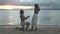 Happy couple, beach and proposal in sunset for engagement, marriage or commitment together. Man on knee for woman