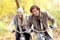 Happy couple on bikes in forest during fall time