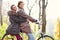 Happy couple on bikes in forest during fall time