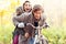 Happy couple on bikes in forest during fall time