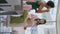 Happy couple blowing bubbles at laundromat vertical. Cute teenagers wash clothes