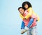 Happy couple, bonding or piggyback portrait on isolated blue background in city travel, date or fun game. Smile, happy