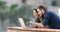 Happy couple browsing laptop content in a balcony