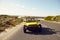 Happy couple in buggy car on open road