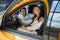 Happy couple of buyers sitting in new car in showroom