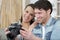 happy couple checks photos on photos camera