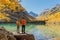 Happy couple at crystal lake in the autumnal mountains. Mountain lake and hikers