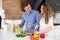 Happy couple cutting vegetables and making salad